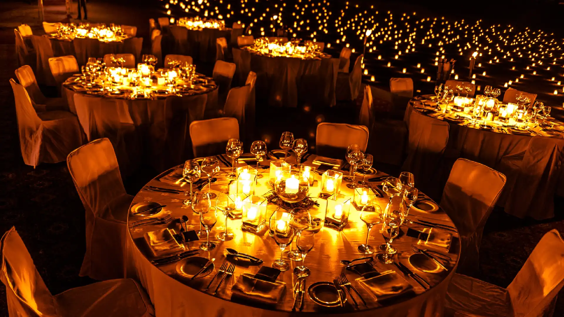Elegant corporate gala dinner with dramatic lighting and premium gold table decor